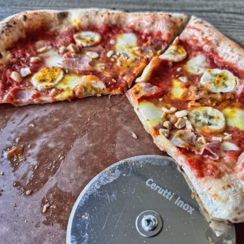 Bananenpizza Pizza Africana auf dem Schneidebrett