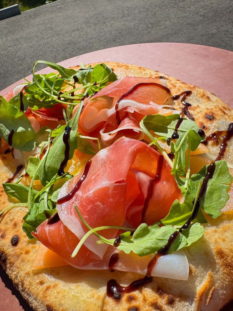 Pizza mit Zuckermelone, Crudo, Rucola und Balsamico